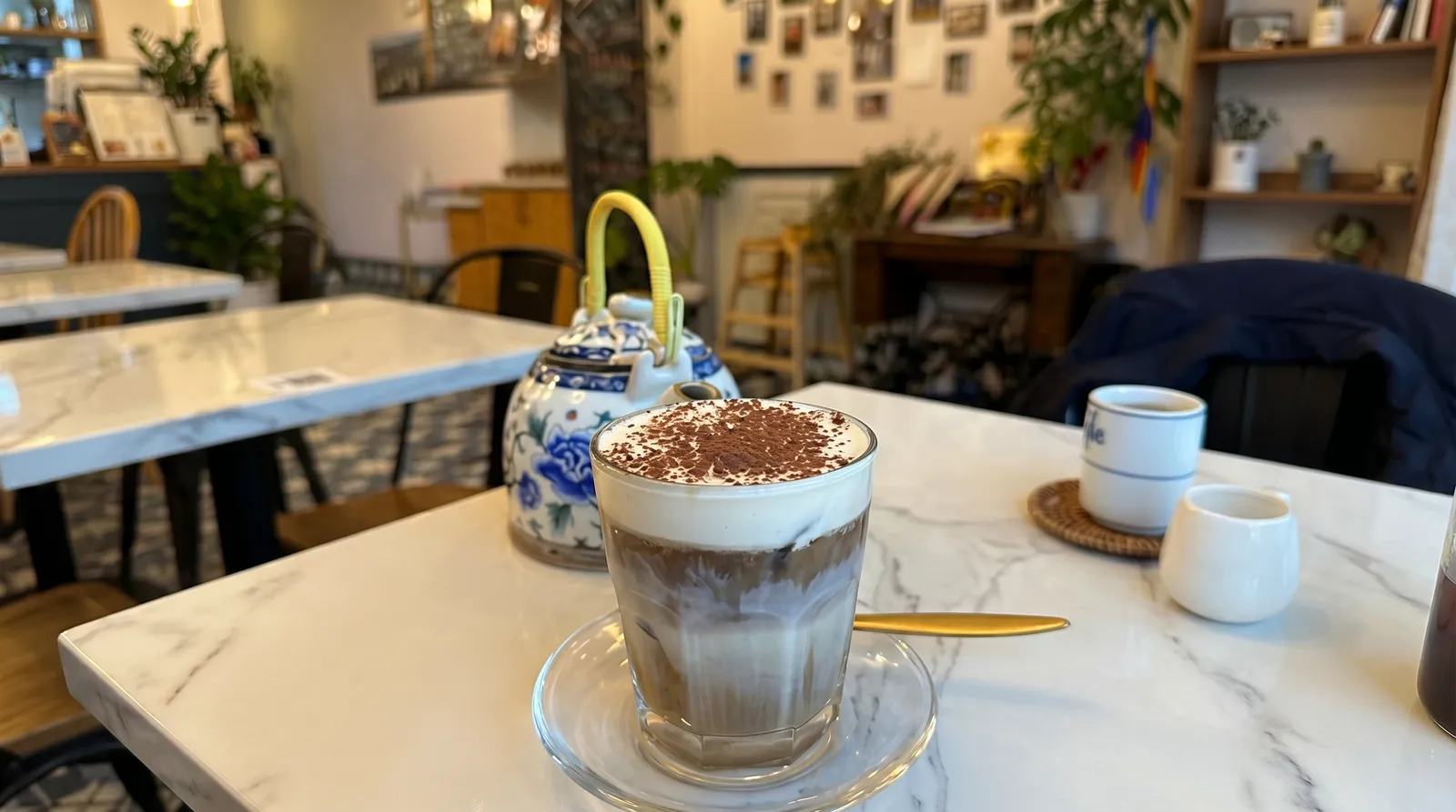 Iced coffee and teapot on a marble table at SAME Vietnamese Eatery